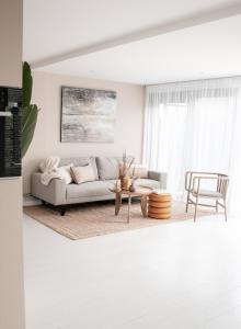 a living room with a couch and a table at Luxe vakantiehuis Nova met zwembad in Ouddorp