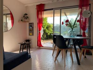 un salon avec une table et des chaises et une fenêtre dans l'établissement La Mer et la Plage au bout du parc Appartement 4 couchages avec jardin, à La Grande Motte