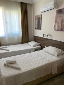 a hotel room with two beds and a window at Sempati Apart Hotel in Alanya