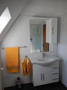a white bathroom with a sink and a mirror at Landhaus Katharina in Westerdeichstrich