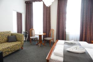 a hotel room with a bed and a chair and a table at Hotel Pension Lumes - Self Check In in Vienna