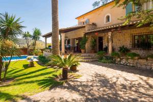une maison avec un palmier en face d'une cour dans l'établissement Casa Eva, à Mancor del Valle