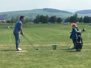 a man and a child playing golf on a field at Horský apartmán Hrebienok A203 in Smokovce