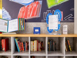 a book shelf in a library with books at ibis budget Paris Porte d'Italie Ouest in Le Kremlin-Bicêtre