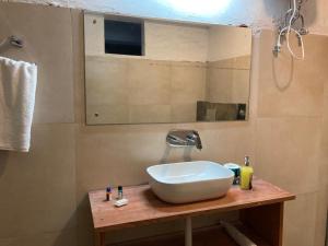 a bathroom with a sink and a mirror at Miknaon Farm Stay in Pedong
