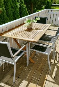 una mesa de madera y sillas en una terraza en Ferienhaus Villa Maria / Ferienwohnung Chippendale en Kurort Gohrisch