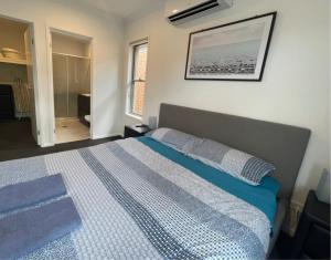 a bedroom with a bed with a blue comforter at Tropical Ocean Vibe Holiday House in Strathpine in Strathpine