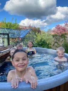 un grupo de niños nadando en una bañera de hidromasaje en Det blågrønne Hus en Hals