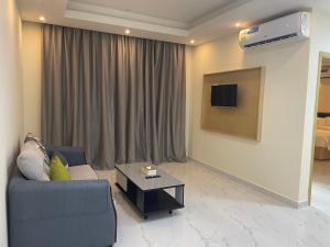 uma sala de estar com um sofá e uma mesa de centro em Season Inn Hotel Apartment_Duqm em Duqm