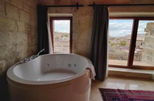 Una bañera en una habitación con una ventana grande. en Concept Cave Suites, en Göreme 56 fotos más