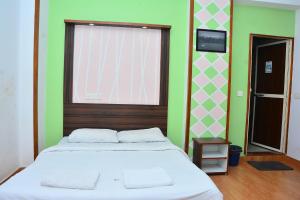 een slaapkamer met een groot bed en een raam bij FabExpress GL Classic With Bar, Porvorim in Oud Goa