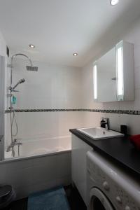 a bathroom with a tub and a sink and a shower at Le Schuss Tignes, appartement cosy 4 personnes in Tignes