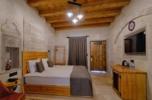 Un dormitorio con una cama y un televisor. en Concept Cave Suites, en Göreme