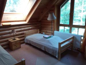 ein Schlafzimmer mit einem Bett in einem Blockhaus in der Unterkunft Holzhaus am See in Zernsdorf