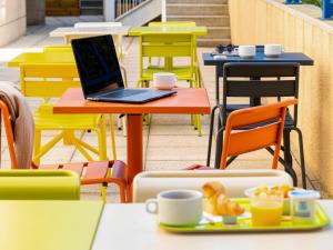 a laptop computer sitting on a table with a plate of food at ibis budget Paris Porte d'Italie Ouest in Le Kremlin-Bicêtre