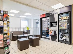 uma sala de espera com um frigorífico e uma mesa em ibis budget Paris Porte d'Italie Ouest em Le Kremlin-Bicêtre