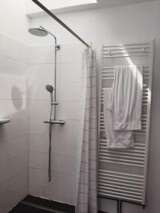 a bathroom with a shower with a white towel at St Elme, maison de pêcheurs, WIFI jardin in Ault