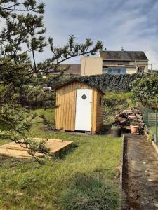 a small shed with a white door in a field at St Elme, maison de pêcheurs, WIFI jardin in Ault