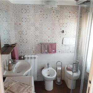 a bathroom with a white sink and a toilet at Stè Sweet home M&A in Scanzano