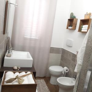 a bathroom with a sink and a toilet and a tub at Stè Sweet home M&A in Scanzano
