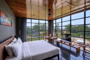 a bedroom with a bed and a table and chairs at Beyond by Sula in Nashik +42 photos