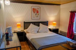 a bedroom with a bed with two tables and two lamps at La Pause Céleste in Ordonnac