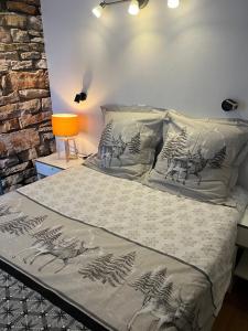 Schlafzimmer mit einem Bett mit grauer und weißer Bettwäsche in der Unterkunft Le Schuss Tignes, appartement cosy 4 personnes in Tignes