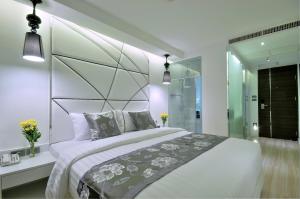 a bedroom with a large bed and a glass wall at Sukhumvit Suites Hotel in Bangkok