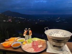 einen Tisch mit Essen, einen Grill und Weinflaschen in der Unterkunft Heaven Khaokho (เฮฟเว่น) in Khao Kho
