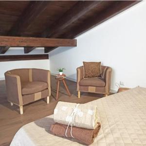 a bedroom with two chairs and a bed at Stè Sweet home M&A in Scanzano