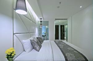 a bedroom with a white bed with pillows at Sukhumvit Suites Hotel in Bangkok