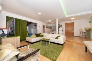 a living room with a white couch and a green curtain at lux apartment in Tučepi
