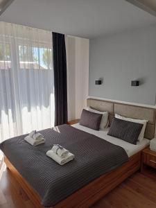 a bedroom with a large bed with two towels on it at Marina Plaza Ozonowane Apartamenty in Jastarnia