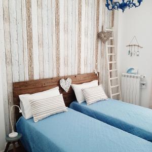 two beds with blue sheets and white pillows in a bedroom at Stè Sweet home M&A in Scanzano
