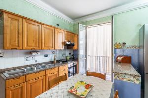 a kitchen with wooden cabinets and a sink and a table at House&Villas - Marina Holiday in Avola