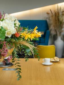 a table topped with a vase filled with flowers at Hotel El Greco in Thessaloniki