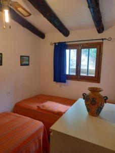 a room with a bed and a vase on a table at L'ALMADRAVA OSTRAS 6 in L'Ametlla de Mar
