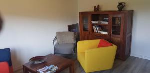 Sala de estar con silla amarilla y mesa en Ferienhof Ziegler Salbei en Baiersbronn