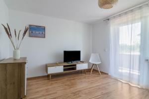 un salon avec une télévision sur un meuble et une fenêtre dans l'établissement Ferienwohnung zum Hecht, à Überlingen