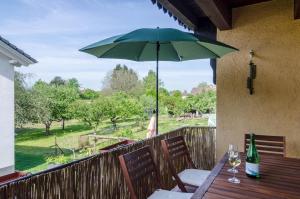 een tafel met een groene paraplu op een terras bij Ferienwohnung zum Hecht in Überlingen