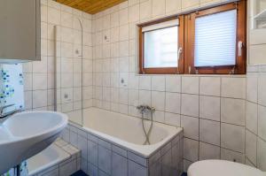 une salle de bain avec une baignoire, un lavabo et des toilettes dans l'établissement Ferienwohnung zum Hecht, à Überlingen 14 autres photos
