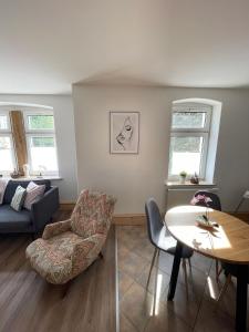 una sala de estar con una mesa y un sofá en Apartmenthaus Elbblick, en Bad Schandau