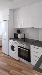 a kitchen with a washing machine and a refrigerator at Acacias IV in Benidorm