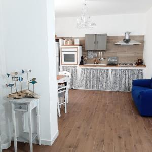 a kitchen with a table and a blue couch in a room at Stè Sweet home M&A in Scanzano