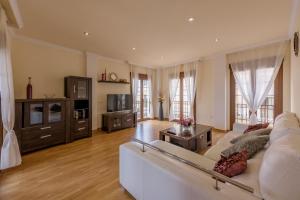 ein Wohnzimmer mit einem weißen Sofa und einem Fernseher in der Unterkunft Apartamento Céntrico Sibarys - 1 dormitorio- Calle Pintada in Nerja