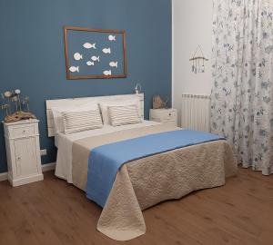 a bedroom with a bed with a blue wall at Stè Sweet home M&A in Scanzano
