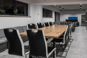a conference room with a wooden table and chairs at Jagodówka in Sablówka