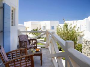 a balcony with chairs and a table with fruit on it at Vencia Boutique Hotel in Mýkonos City
