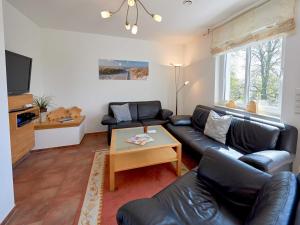 - un salon avec un canapé en cuir noir et une table dans l'établissement Haus Strandjuwel - Haus 2 "Sonnenträumer" mit Sauna, Kamin, Terrasse, à Sellin