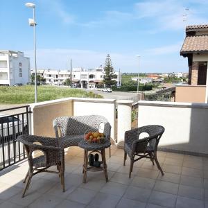 a balcony with two chairs and a table with fruit on it at Stè Sweet home M&A in Scanzano